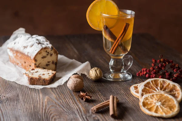 Traditional hot toddy winter drink with spices recipe. Fresh homemade cake holiday on a wooden background.