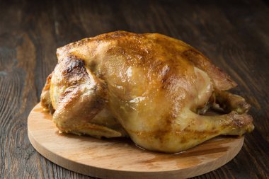 Kızarmış tavuğun tamamı ahşap kesme tahtasında.