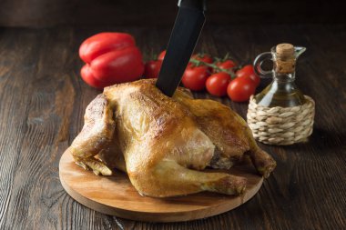 Fırında tavuk domates, yağ ve ahşap kesme tahtası, rustik arka plan üzerinde biber ile.