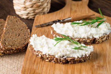 Tereyağı ve rustik ahşap arka plan kopya alanı ile üzerinden rosemary ile kahvaltıda ekmek