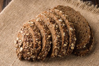 Taze ev yapımı ekmek, yulaf gevreği ve ayçiçeği seedson gri bir arka plan üzerinde keten bir havlu. Üstten görünüm