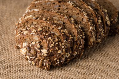 Taze ev yapımı ekmek, yulaf gevreği ve ayçiçeği seedson gri bir arka plan üzerinde keten bir havlu. Üstten görünüm