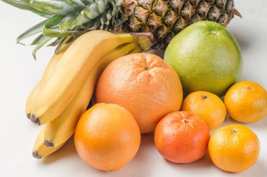 Taze tropikal meyve. portakal, muz, ananas, mandalina, greyfurt. Beyaz bir arka plan üzerinde.