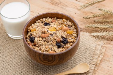 Granola kase, müsli yulaf, fındık ve kuru meyve, süt, ile ile ahşap masaya servis kahvaltı. Sağlıklı kahvaltı. Diyet.