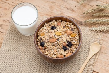 Granola kase, müsli yulaf, fındık ve kuru meyve, süt, ile ile ahşap masaya servis kahvaltı. Sağlıklı kahvaltı. Diyet.