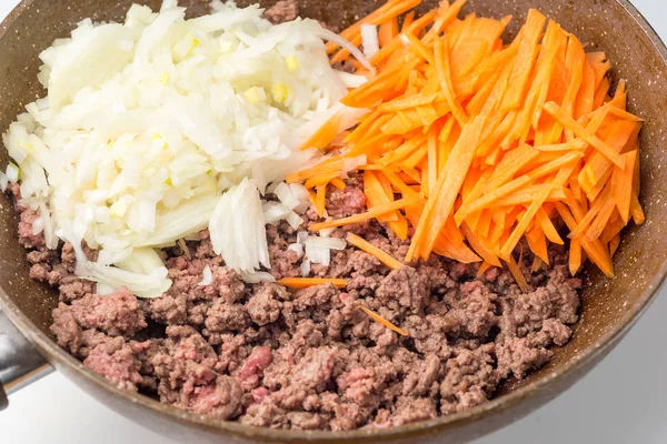 Hackfleisch, Zwiebeln und Karotten in der Pfanne anbraten — Stockfoto