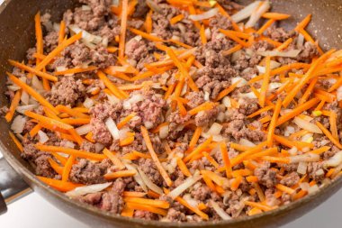 Fried kıyma, soğan ve havuç tava üzerinde