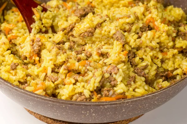 Frying pan full of yellow rice minced meat and wooden shovel — Stock Photo, Image