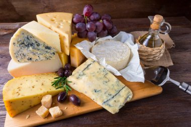 Ahşap arka plan üzerinde üzüm ile Peynir tabağı servis