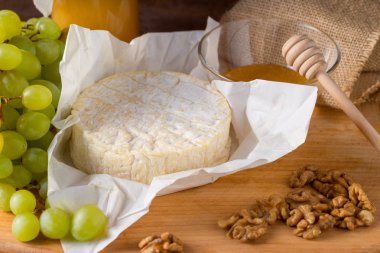 Tatlım, meyve ve fındık ile ahşap bir gemide Camembert peyniri