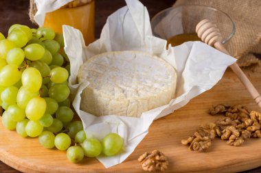 Tatlım, meyve ve fındık ile ahşap bir gemide Camembert peyniri