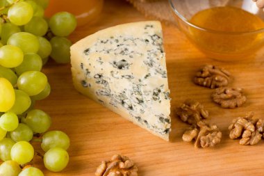 Üçgen mavi peynir ahşap kesme tahtası üzerinde