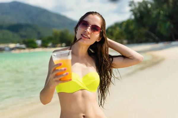 Jovem com suco de laranja na praia na Tailândia — Fotografia de Stock