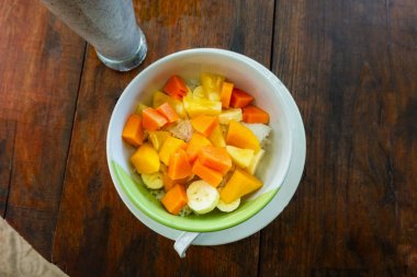 Ahşap arka plan üzerinde kase karışık meyve salatası