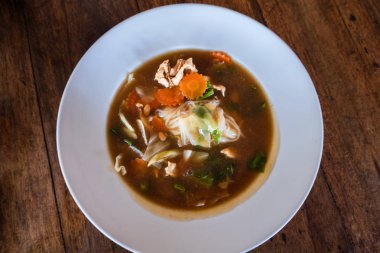 Beyaz tabakta istiridye çorbası karışık tofu ve tavuk.