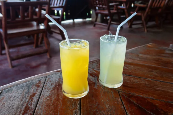 Dos vasos de zumo fresco de naranja y limón sobre la mesa . — Foto de Stock