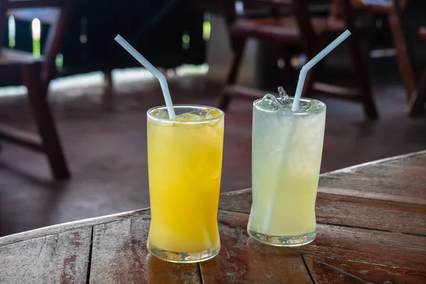 Due bicchieri di arancia fresca e succo di limone sul tavolo . — Foto Stock