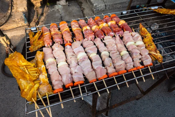 Grilled kebab cooking on metal skewer. Roasted meat cooked at ba