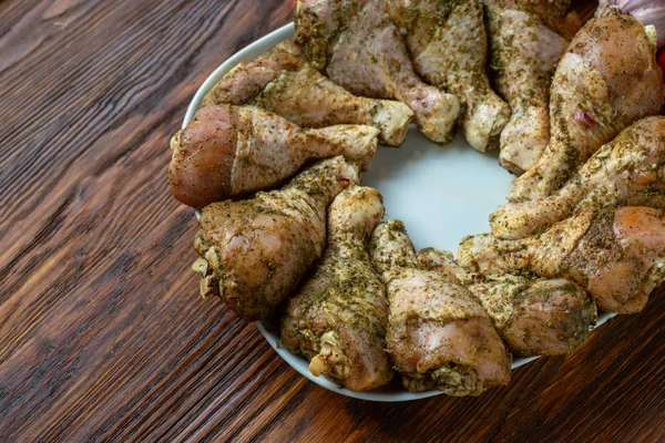 Nyers, nyersen főtt csirkecomb a hagymás kerek tányéron, paradicsom és — Stock Fotó