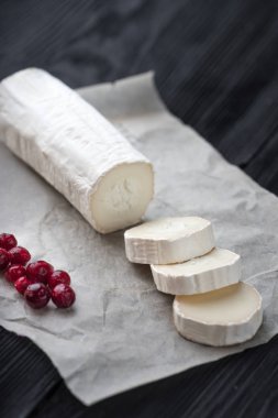 Kağıt üzerinde kırmızı çilek dilimleri ile taze keçi peyniri.