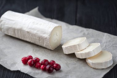 Kağıt üzerinde kırmızı çilek dilimleri ile taze keçi peyniri.