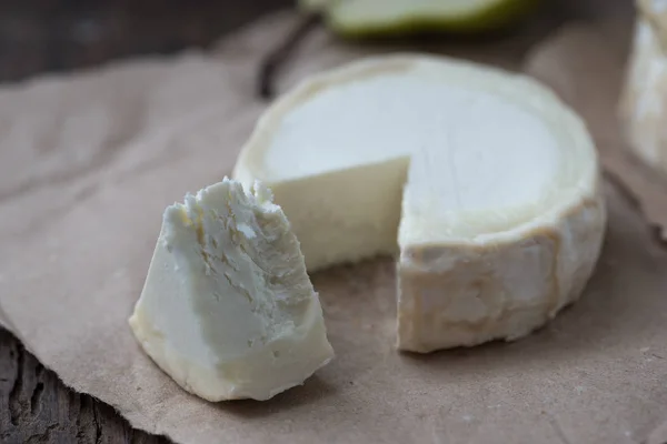 Pezzo di formaggio camembert puzzolente su un tavolo rustico in legno — Foto Stock