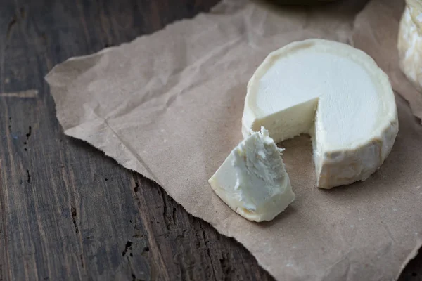 Bit illaluktande camembert ost på ett rustikt träbord — Stockfoto