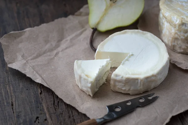 Pezzo di formaggio camembert puzzolente su un tavolo rustico in legno — Foto Stock