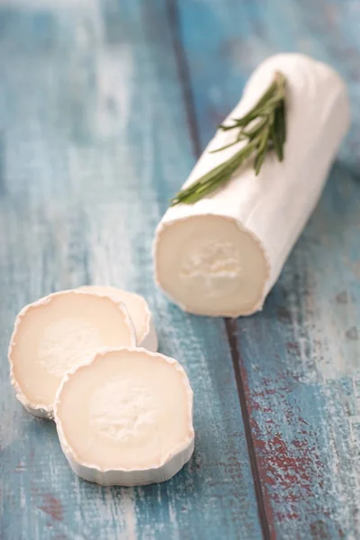 Čerstvý kozí sýr s plátky na papíře. — Stock fotografie