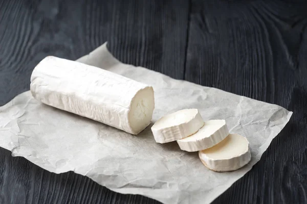 Formaggio di capra fresco con fette su carta . — Foto Stock