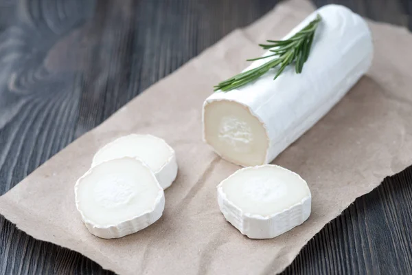 Čerstvý kozí sýr s plátky na papíře. — Stock fotografie