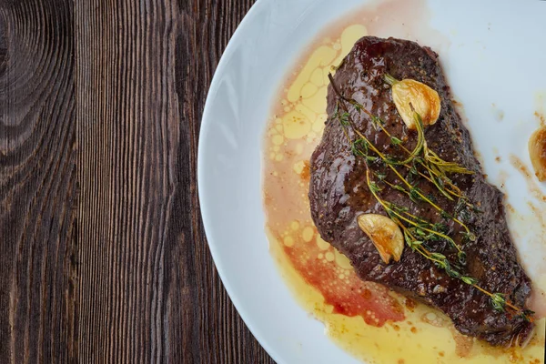 Rib-eye steak resting on a white plate — Stock Photo, Image