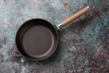 Koyu yeşil mutfak arka plan üzerinde boş dökme demir kızartma tavası, vi
