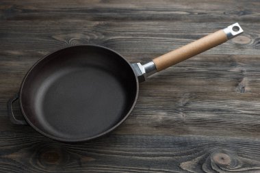 Rustik ahşap arka plan üzerinde dökme demir tava yakın