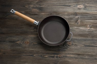 Rustik ahşap arka plan üzerinde dökme demir tava, üst görünümü