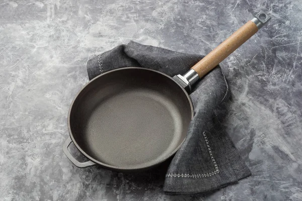 Poêle en fonte vide sur fond culinaire gris foncé . — Photo