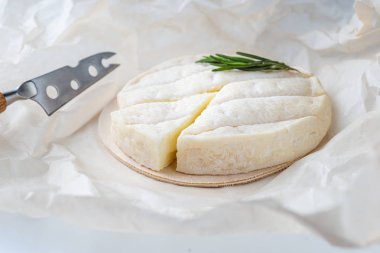 Taze Brie peyniri ve taze rosema ile ahşap bir tahta üzerinde bir dilim