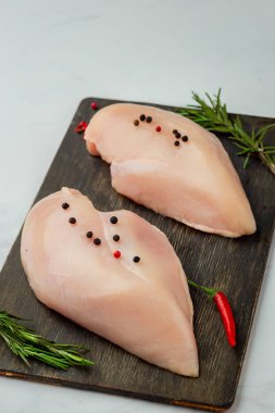 Koyu ahşap tahta üzerinde çiğ tavuk fileto