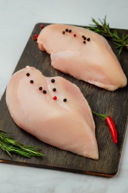 Koyu ahşap tahta üzerinde çiğ tavuk fileto