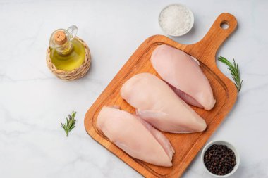 Malzemelerle bir kesme masada çiğ pişmemiş tavuk fileto 