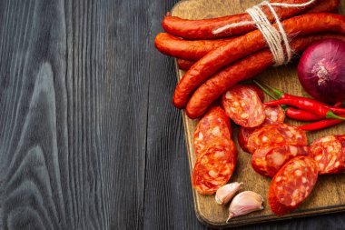 Fesleğen ve baharatlar ile ahşap bir tahta üzerinde kurutulmuş sosis. Rustik fo