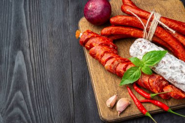 Fesleğen ve baharatlar ile ahşap bir tahta üzerinde kurutulmuş sosis. Rustik fo