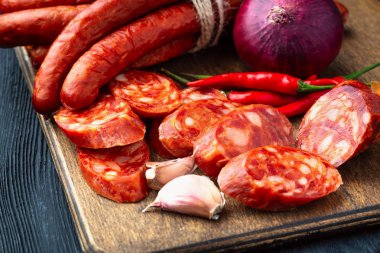 Fesleğen ve baharatlar ile ahşap bir tahta üzerinde kurutulmuş sosis. Rustik fo