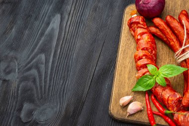 Fesleğen ve baharatlar ile ahşap bir tahta üzerinde kurutulmuş sosis. Rustik fo