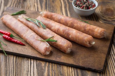 Koyu ahşap arka plan üzerinde sıcak baharat ile Ham sosis