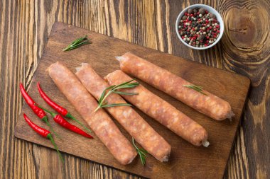 Koyu ahşap arka plan üzerinde sıcak baharat ile Ham sosis