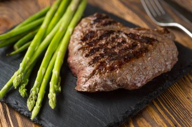 Et masası : Ahşap masa üzerinde kuşkonmaz ile ızgara sığır filetosu