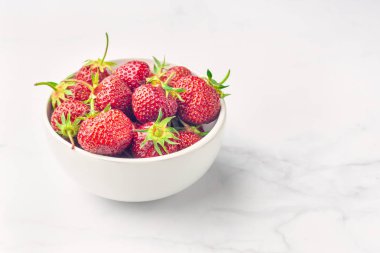 Beyaz kase ve çatal taze organik çilek, Whit üzerinde