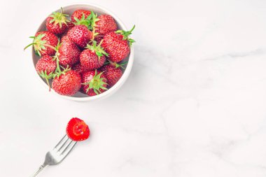 Beyaz kase ve çatal taze organik çilek, Whit üzerinde