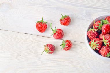 Ahşap bir masada bir kase taze çilek. Close